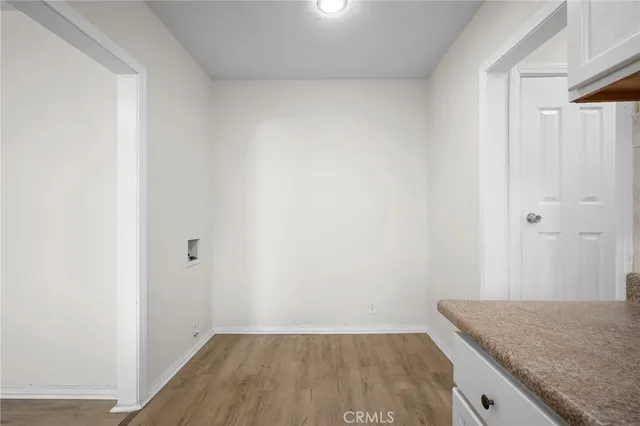 a view of kitchen island a sink wooden floor and entryway