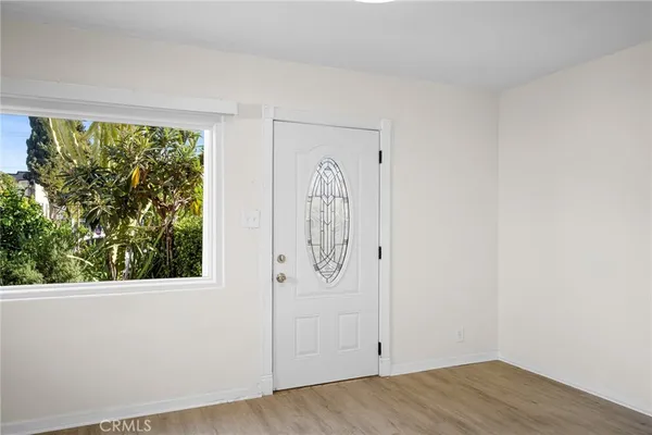 an empty room with wooden floor and mirror