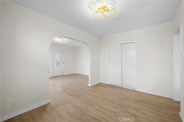 an empty room with a wooden floor and window