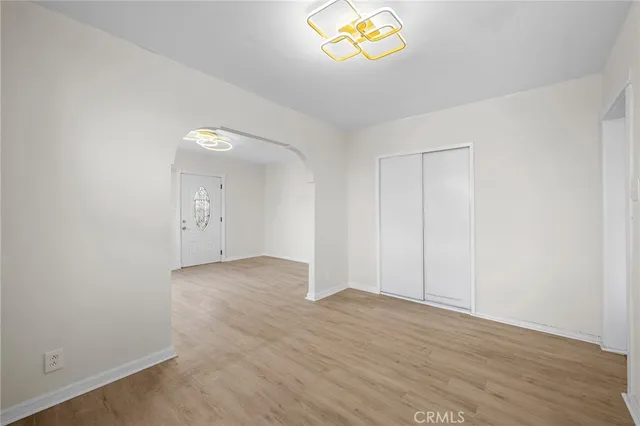 an empty room with a wooden floor and window