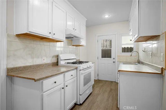 a kitchen with granite countertop white cabinets and white appliances