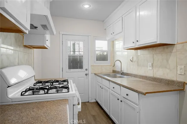 a kitchen with sink a stove and a refrigerator