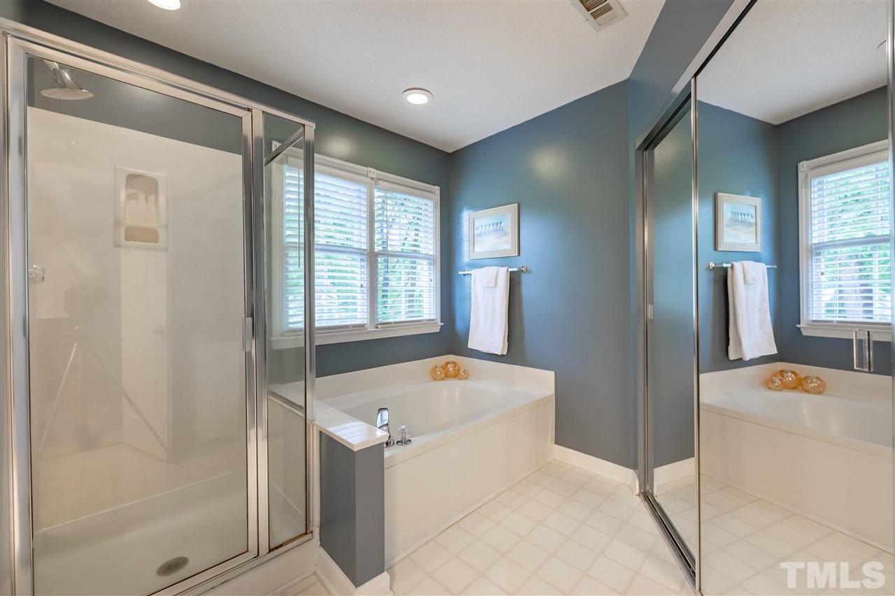 5304 Denmead Way Raleigh, NC 27613 - Photo 11 of 19 a bathroom with a tub a sink and mirror