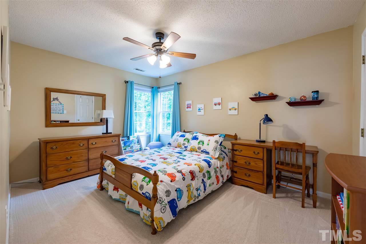 5304 Denmead Way Raleigh, NC 27613 - Photo 14 of 19 a bedroom with a bed and a chandelier