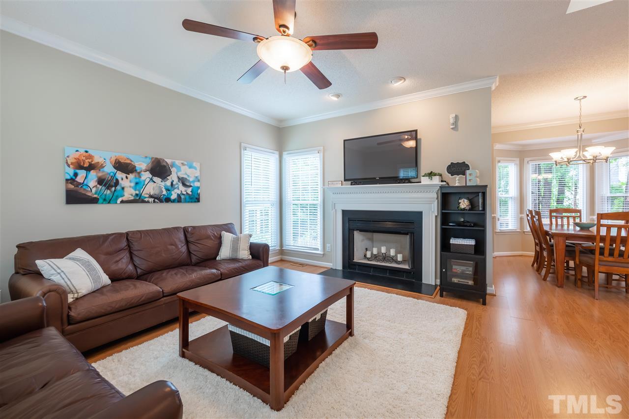 5304 Denmead Way Raleigh, NC 27613 - Photo 3 of 19 a living room with furniture a flat screen tv and a fireplace