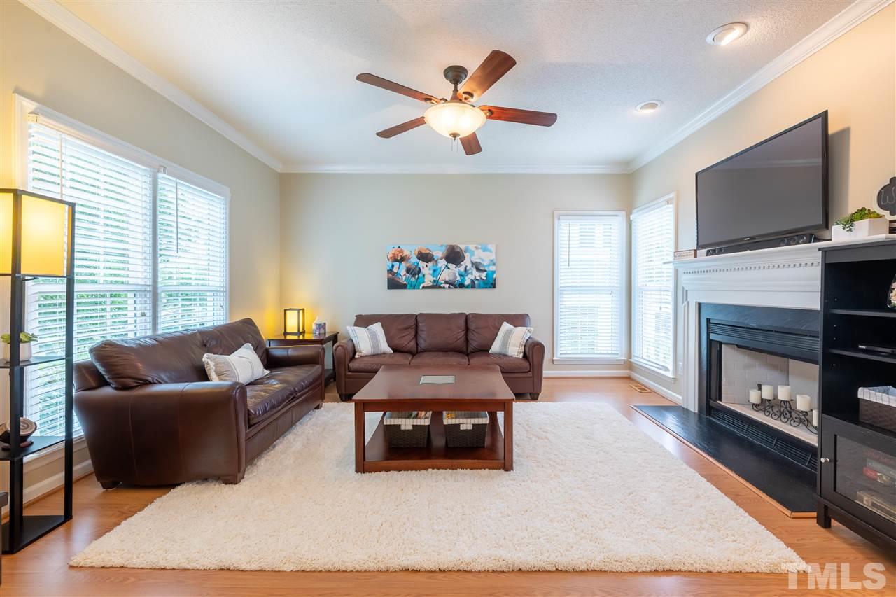 5304 Denmead Way Raleigh, NC 27613 - Photo 4 of 19 a living room with furniture a fireplace and a flat screen tv
