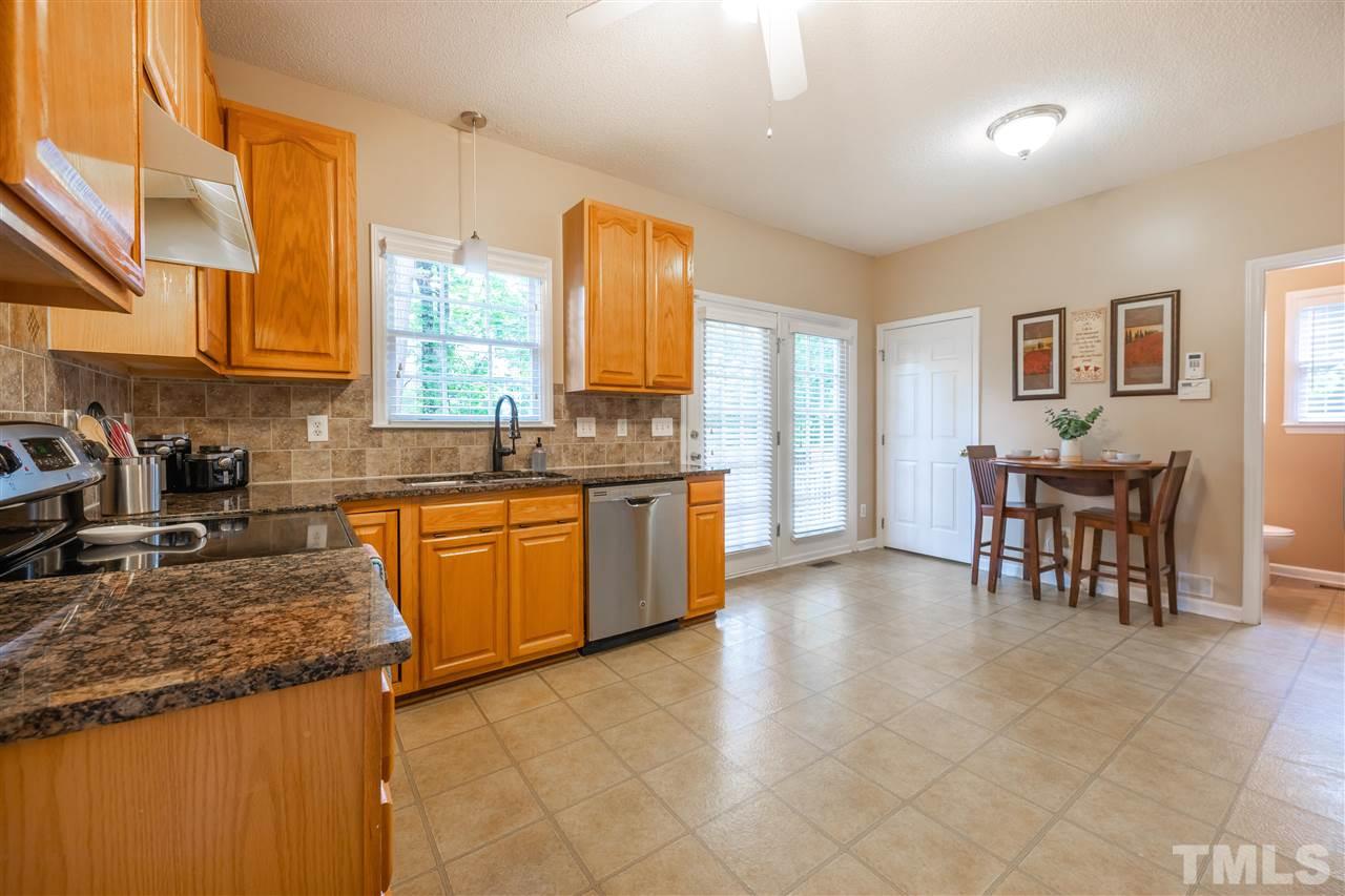 5304 Denmead Way Raleigh, NC 27613 - Photo 7 of 19 a kitchen with stainless steel appliances granite countertop a stove a sink a dining table and chairs