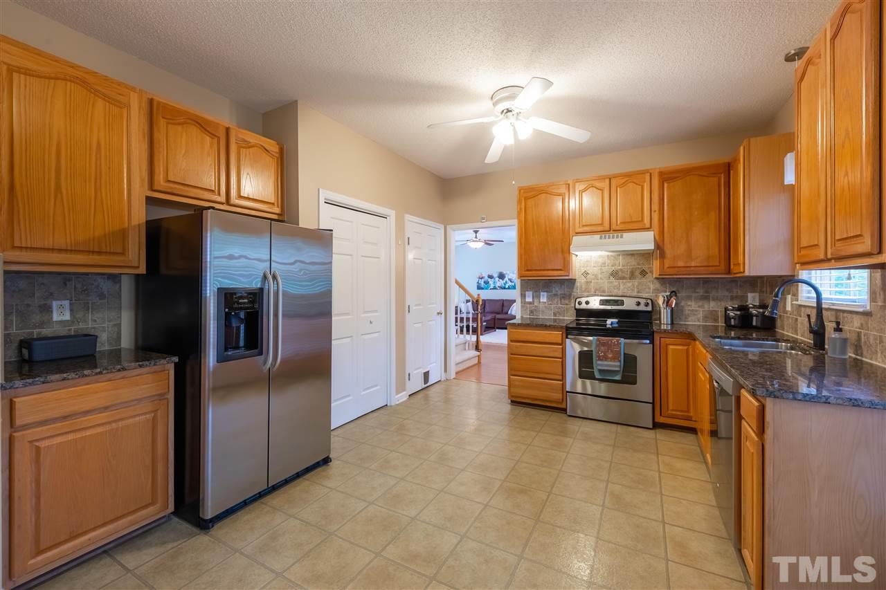 5304 Denmead Way Raleigh, NC 27613 - Photo 8 of 19 a kitchen with stainless steel appliances granite countertop a stove top oven a refrigerator a sink and dishwasher