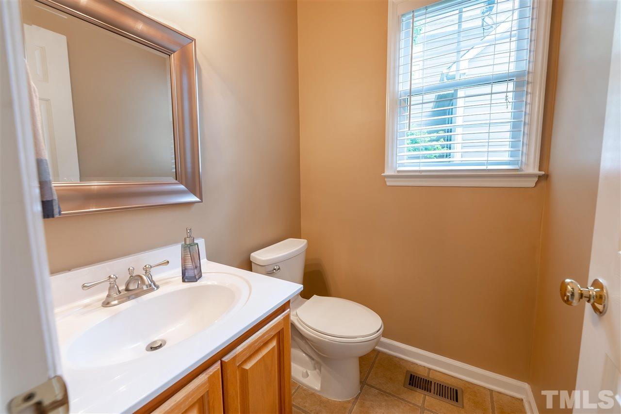 5304 Denmead Way Raleigh, NC 27613 - Photo 9 of 19 a bathroom with a toilet a sink a mirror and a window