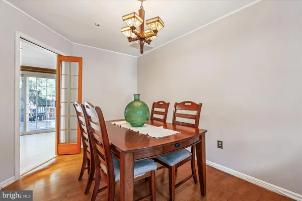 a kitchen with granite countertop a refrigerator a sink dishwasher a dining table and chairs with wooden floor