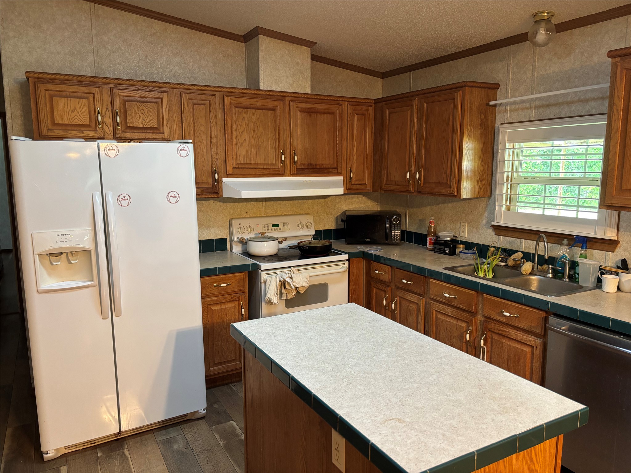 35599 State Highway South Buna, TX 77612 - Photo 20 of 40 a kitchen with a refrigerator a stove a sink dishwasher and wooden cabinets