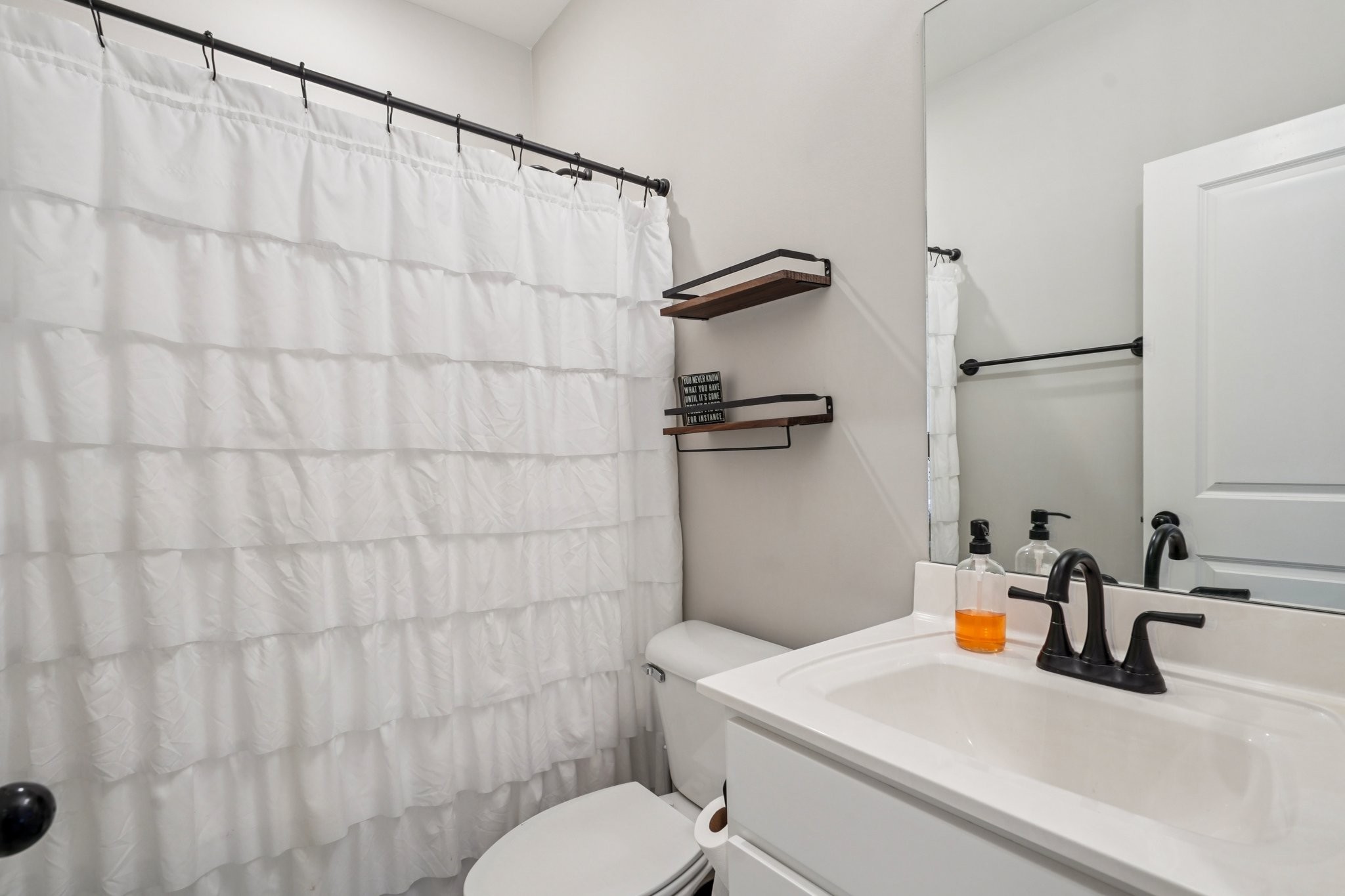 258 Woodruff Road Adams, TN 37010 - Photo 20 of 49 a bathroom with a sink a toilet and shower curtain
