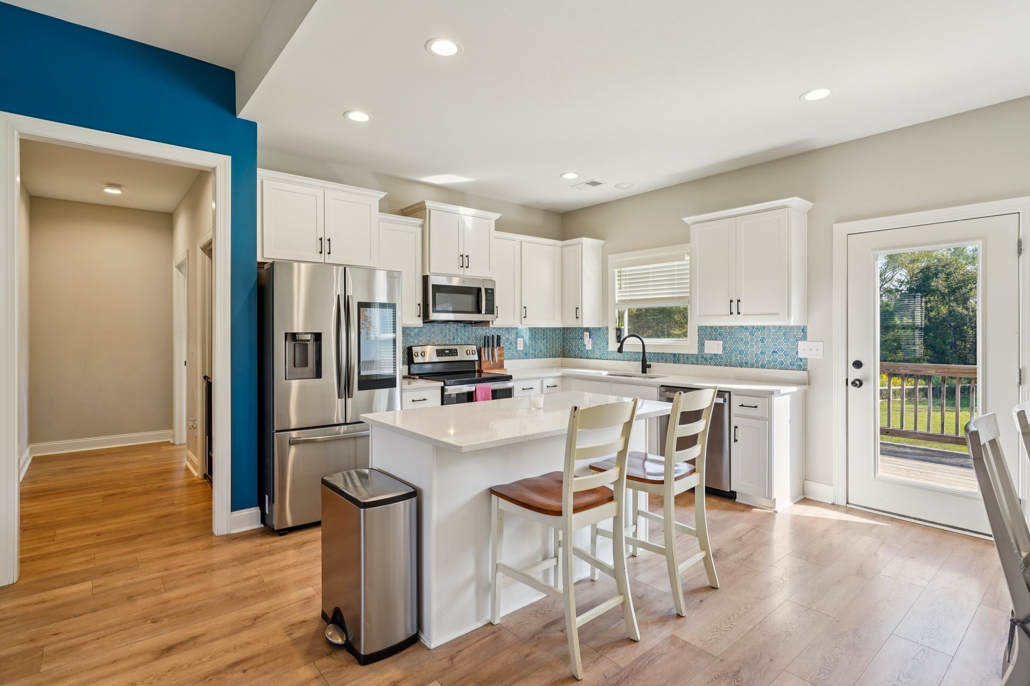 258 Woodruff Road Adams, TN 37010 - Photo 2 of 49 a kitchen with stainless steel appliances a refrigerator a stove a sink dishwasher and white cabinets with wooden floor