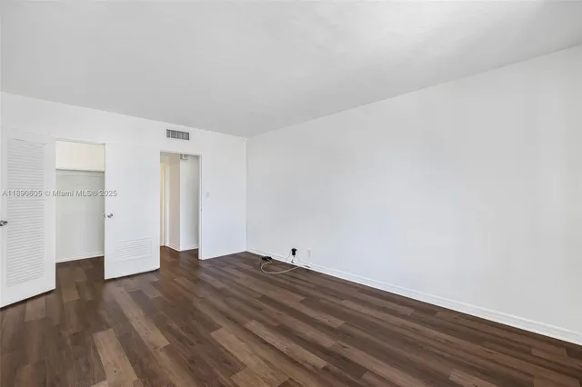a big room with wooden floor and windows