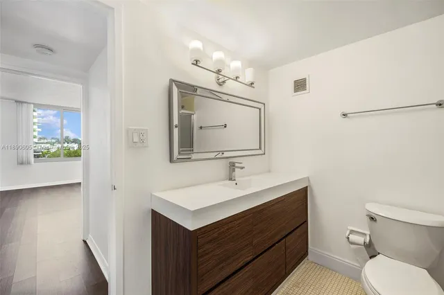 a bathroom with a sink a toilet and mirror