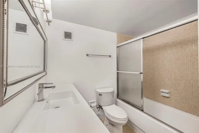 a white toilet sitting next to a bath tub