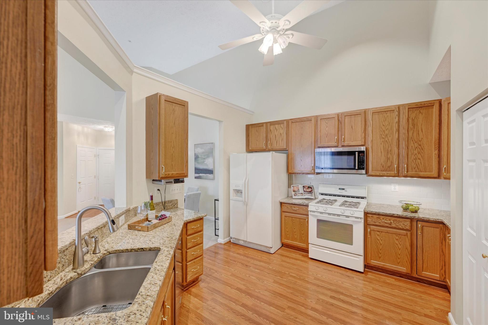 9606 Haven Farm Road, Unit 9606M Perry Hall, MD 21128 - Photo 13 of 49 a kitchen with stainless steel appliances granite countertop a sink dishwasher stove and refrigerator with wooden floor