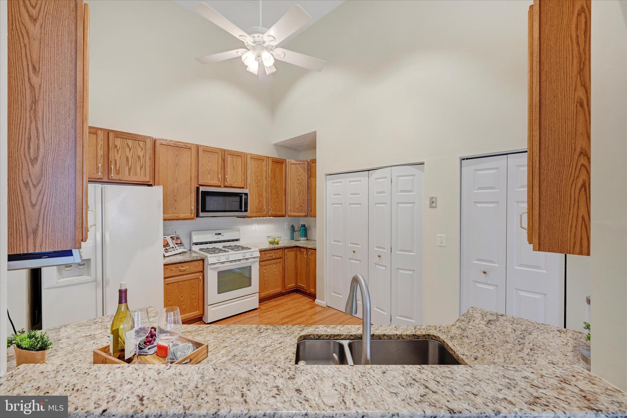 9606 Haven Farm Road, Unit 9606M Perry Hall, MD 21128 - Photo 18 of 49 a kitchen with stainless steel appliances granite countertop a sink refrigerator stove and microwave