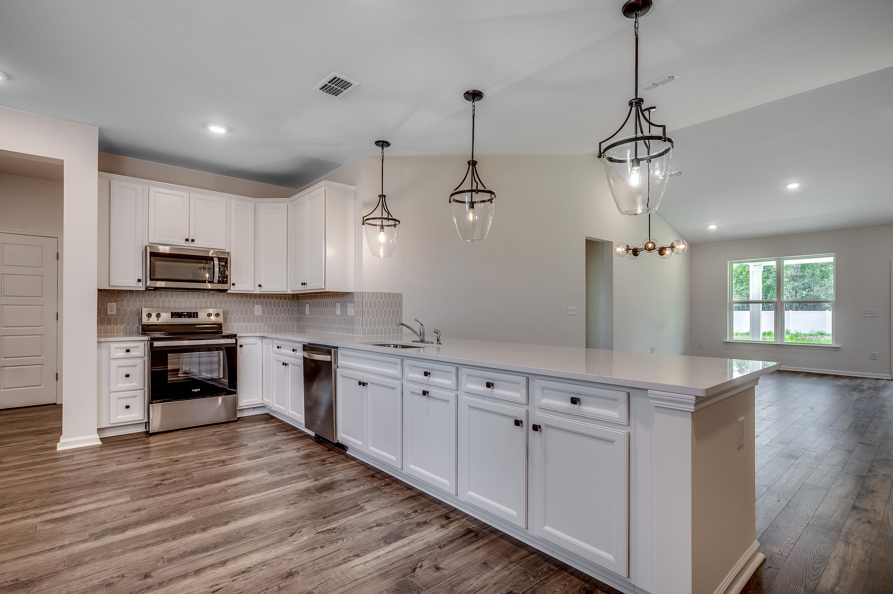 133 Buckingham Drive Loris, SC 29569 - Photo 8 of 17 Kitchen with white cabinetry, stainless steel appliances, pendant lighting, lofted ceiling, and recessed lighting