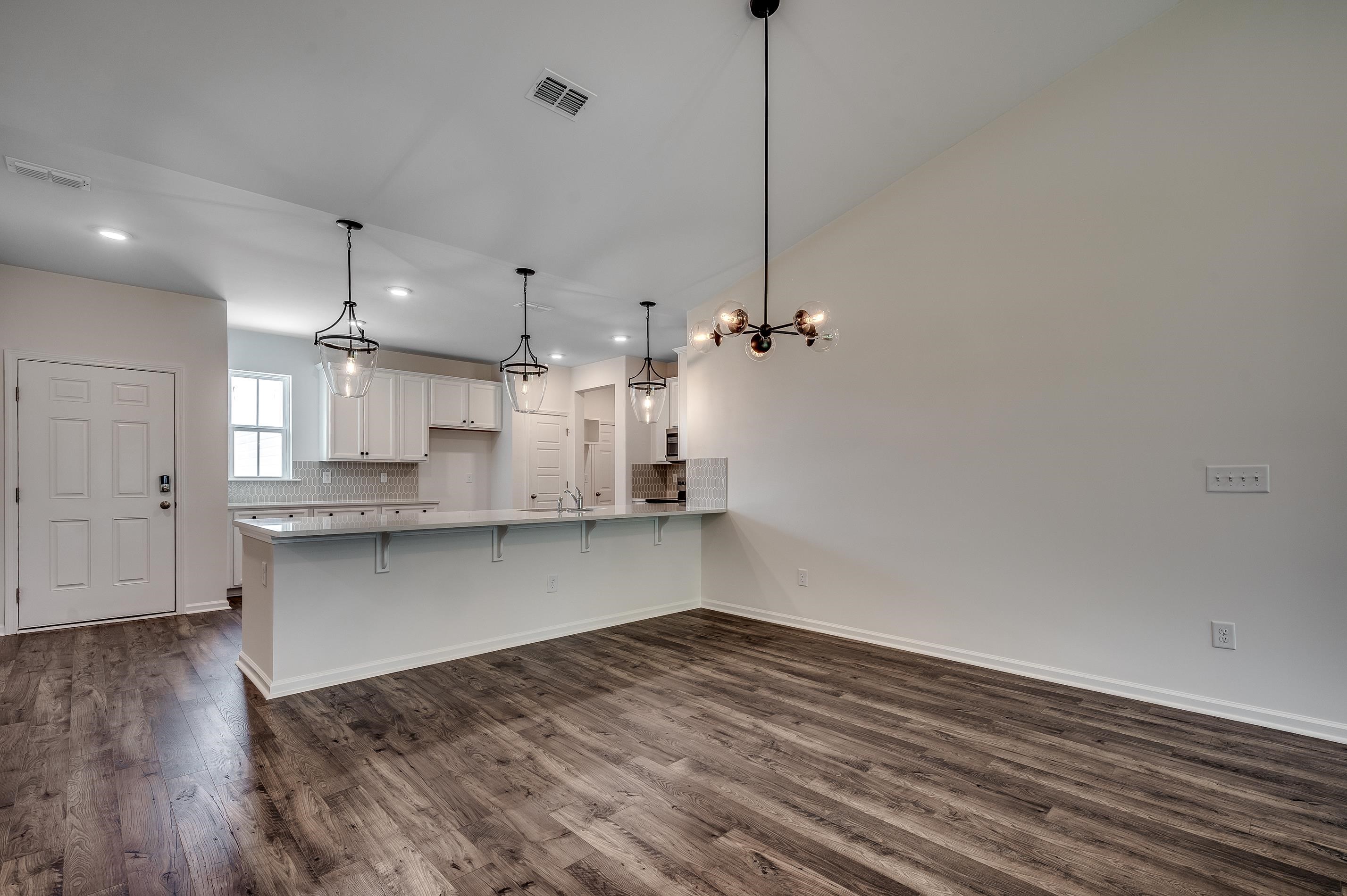 133 Buckingham Drive Loris, SC 29569 - Photo 10 of 17 Kitchen featuring a breakfast bar, a peninsula, white cabinetry, dark wood-type flooring, and recessed lighting