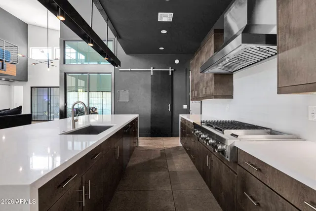 a kitchen with stainless steel appliances granite countertop a sink a stove and a wooden floors