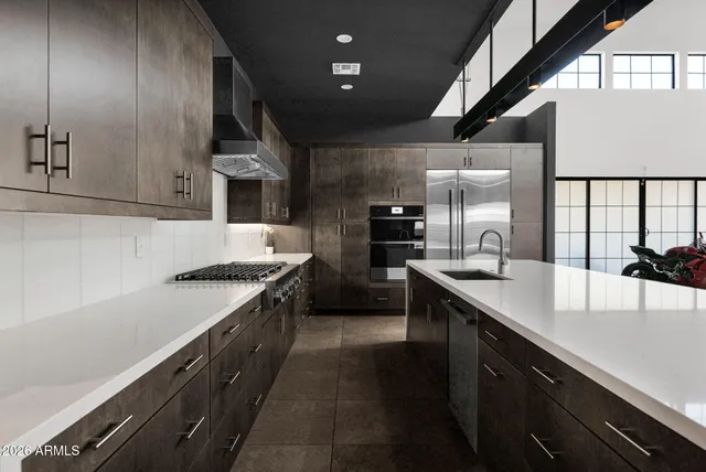 a kitchen with stainless steel appliances granite countertop a sink a stove and a refrigerator