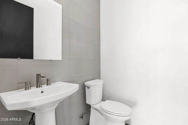 a bathroom with a sink a toilet and mirror