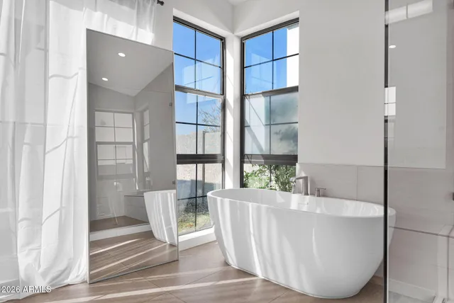 a bathroom with a bathtub and next to a window