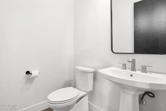 a bathroom with a toilet a sink and mirror