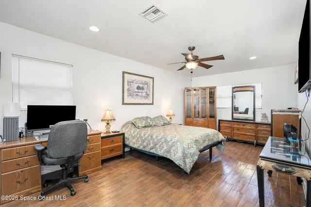 a bedroom with a bed desk and a window