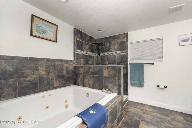 a bathroom with a tub a sink and glass door