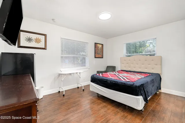 a bedroom with a bed and a flat screen tv