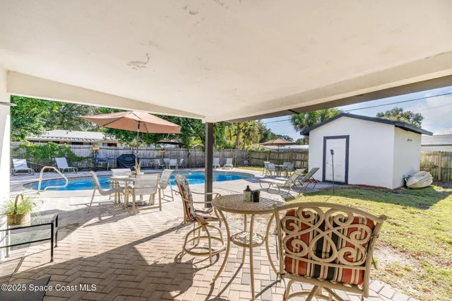a view of a patio with dining table and chairs with wooden floor