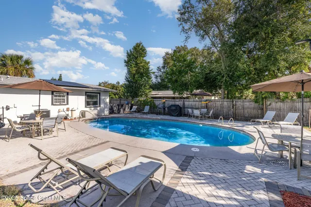 a view of a patio with table and chairs under an umbrella