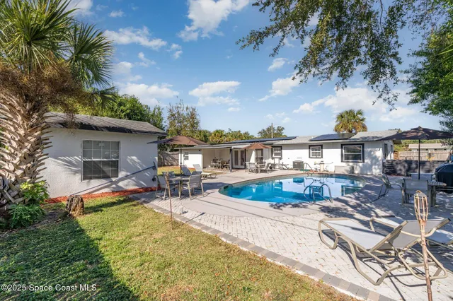 a view of a house with swimming pool and sitting area