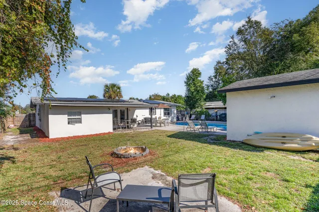 a view of a house with backyard and sitting area
