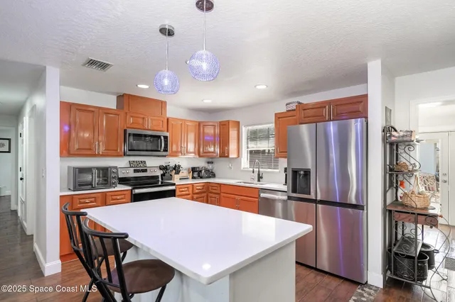a kitchen with stainless steel appliances a refrigerator sink microwave and cabinets