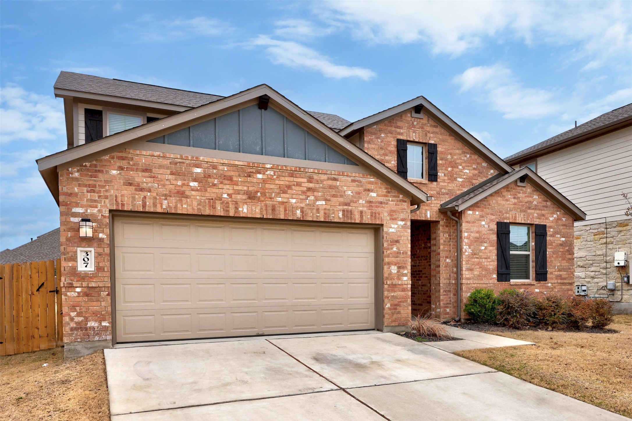 307 Simmental Loop Hutto, TX 78634 - Photo 2 of 34 A classic brick exterior with well-maintained landscaping and a spacious two-car garage.