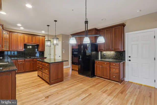 a view of an empty room with wooden floor and windows