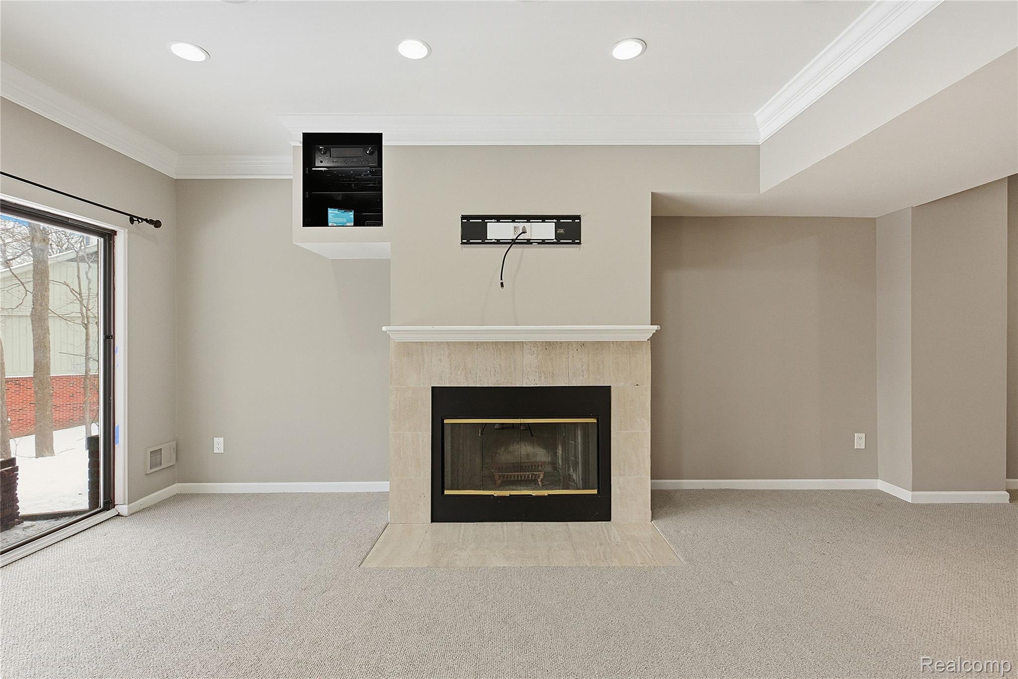 7154 Westchester Road West Bloomfield, MI 48322 - Photo 5 of 38 Unfurnished living room featuring a tile fireplace, carpet floors, crown molding, and recessed lighting