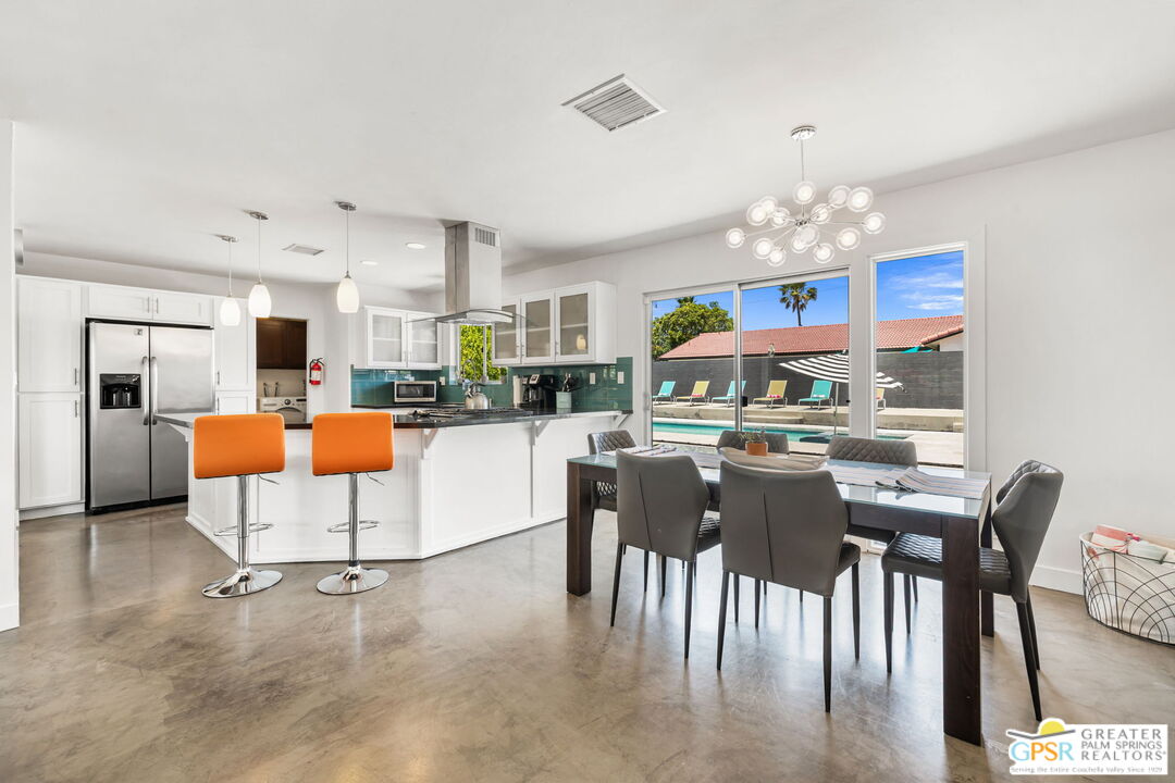 490 East Molino Road Palm Springs, CA 92262 - Photo 20 of 47 a dining room with kitchen island stainless steel appliances furniture a chandelier and kitchen view