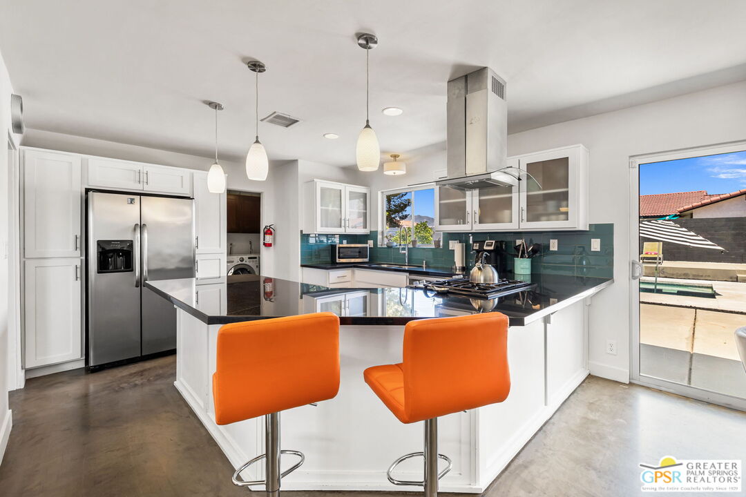 490 East Molino Road Palm Springs, CA 92262 - Photo 23 of 47 a kitchen with stainless steel appliances granite countertop a stove a sink a refrigerator and chairs