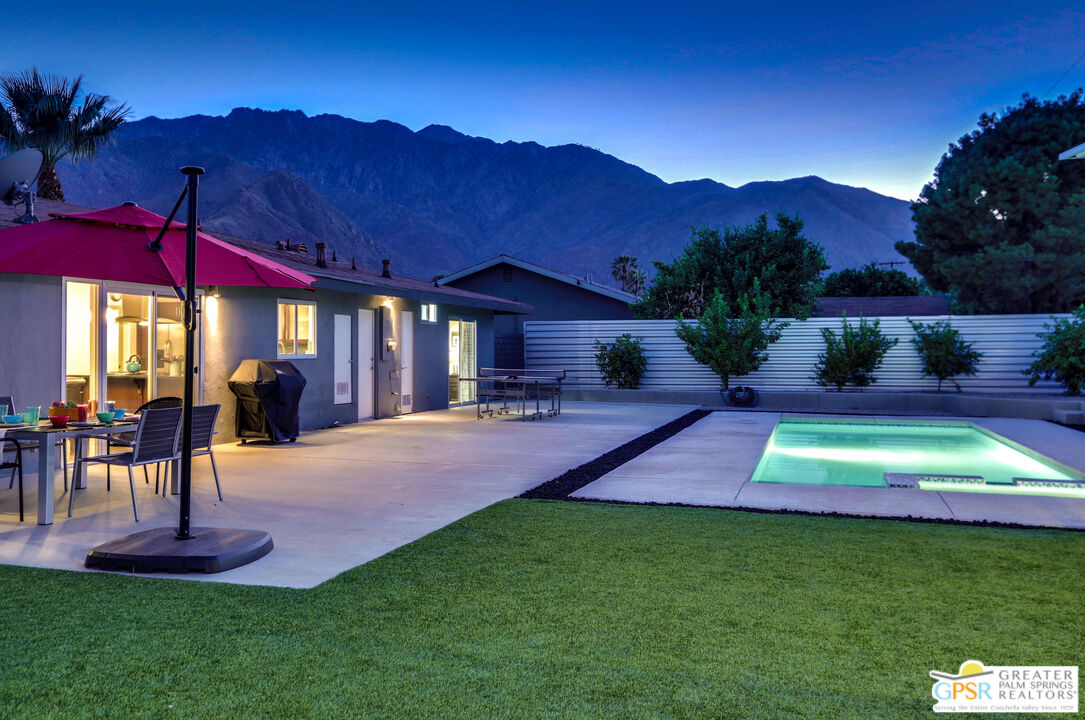 490 East Molino Road Palm Springs, CA 92262 - Photo 5 of 47 a view of a swimming pool with a table and chairs under an umbrella