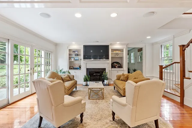 a living room with fireplace furniture and a large window