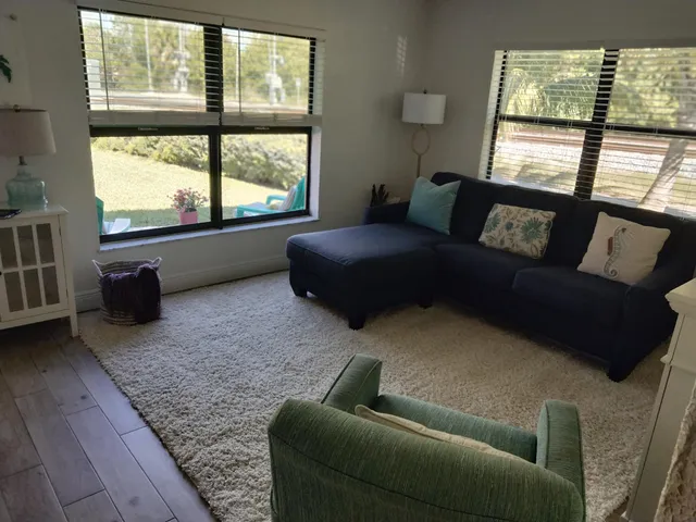 a living room with furniture and a floor to ceiling window