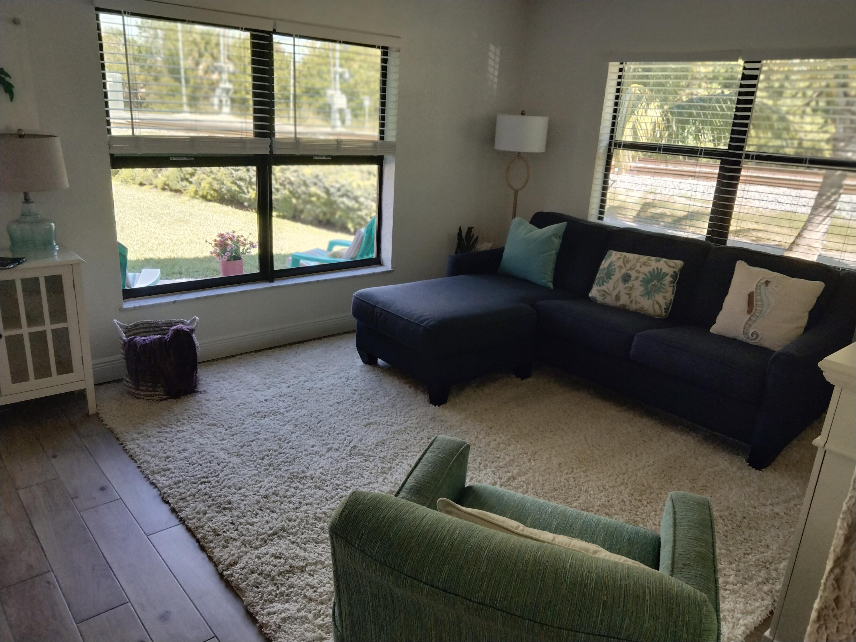 1150 Northeast County Line Road Jensen Beach, FL 34957 - Photo 2 of 17 a living room with furniture and a floor to ceiling window