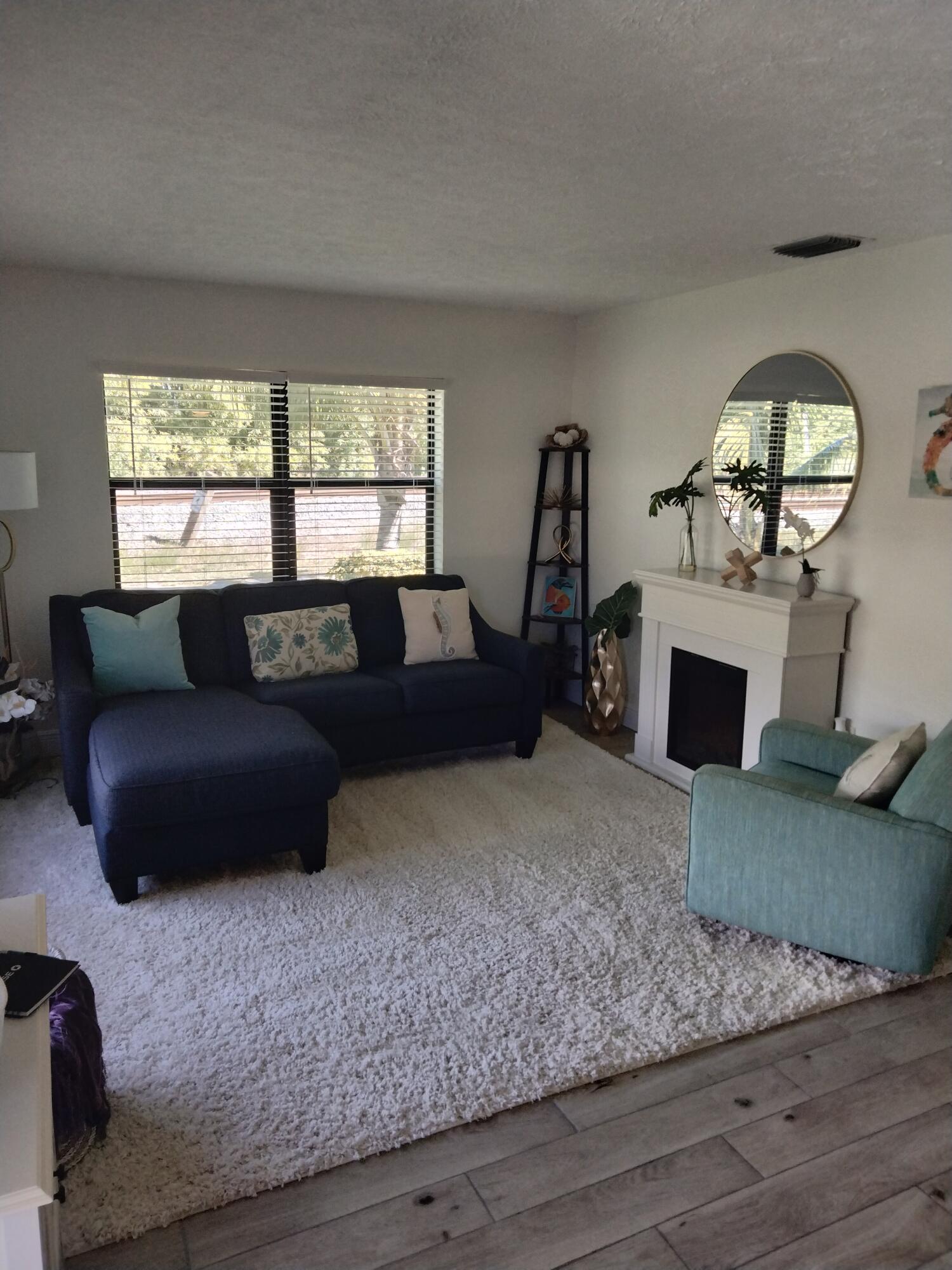 1150 Northeast County Line Road Jensen Beach, FL 34957 - Photo 3 of 17 a living room with furniture and a fireplace
