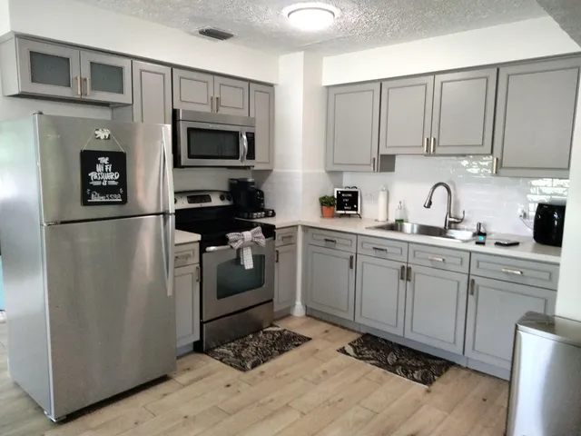 a kitchen with cabinets stainless steel appliances and a counter space