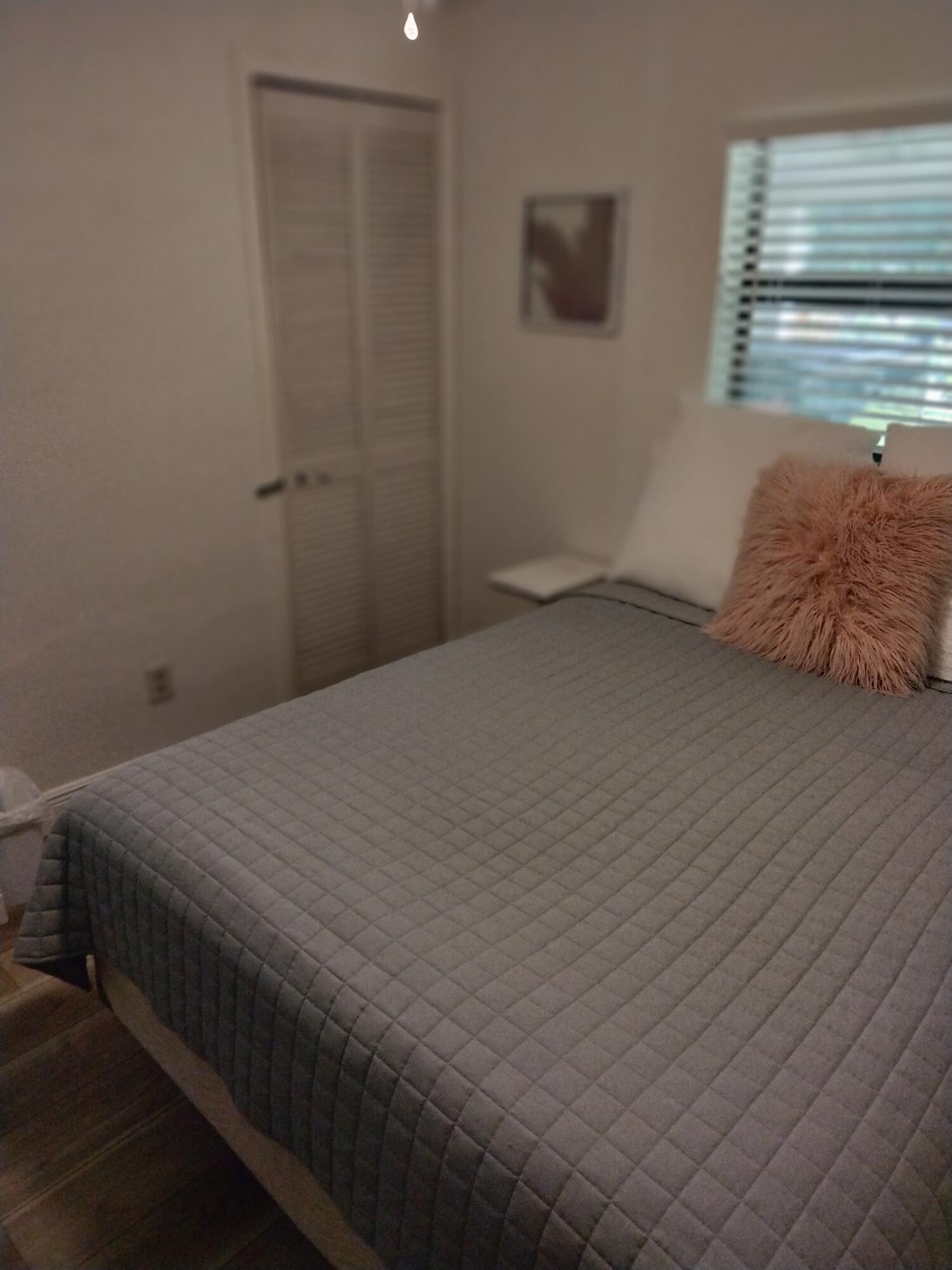 1150 Northeast County Line Road Jensen Beach, FL 34957 - Photo 7 of 17 a bedroom with a bed and a window