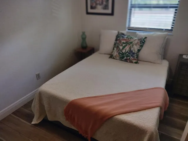 a bed sitting in a bedroom next to a window